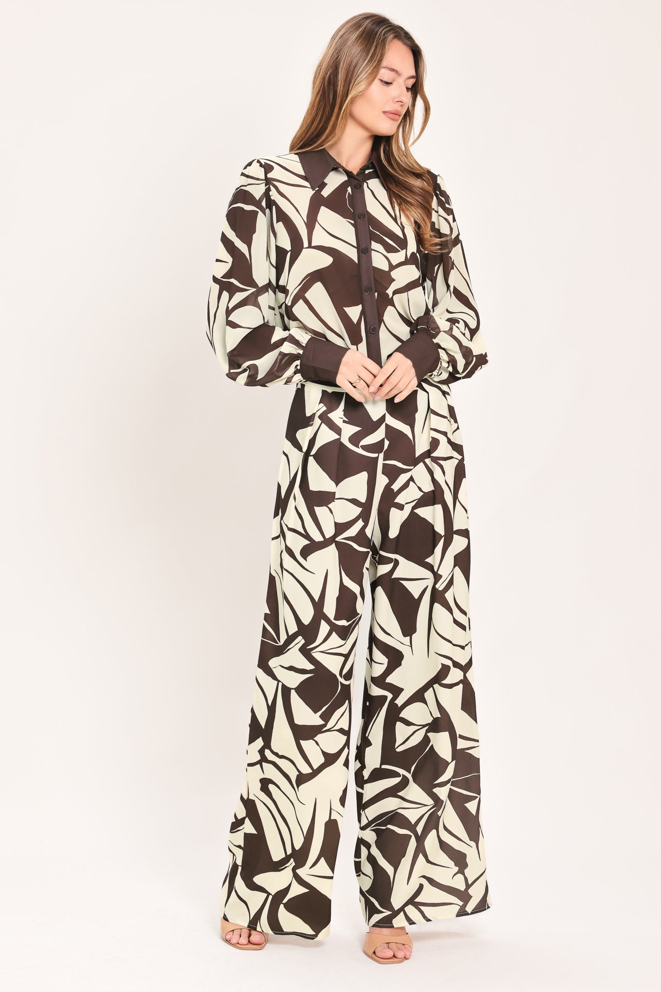 A woman wearing loose, wide-leg pants with an abstract leaf-like print in dark brown and off-white | Flying Tomato