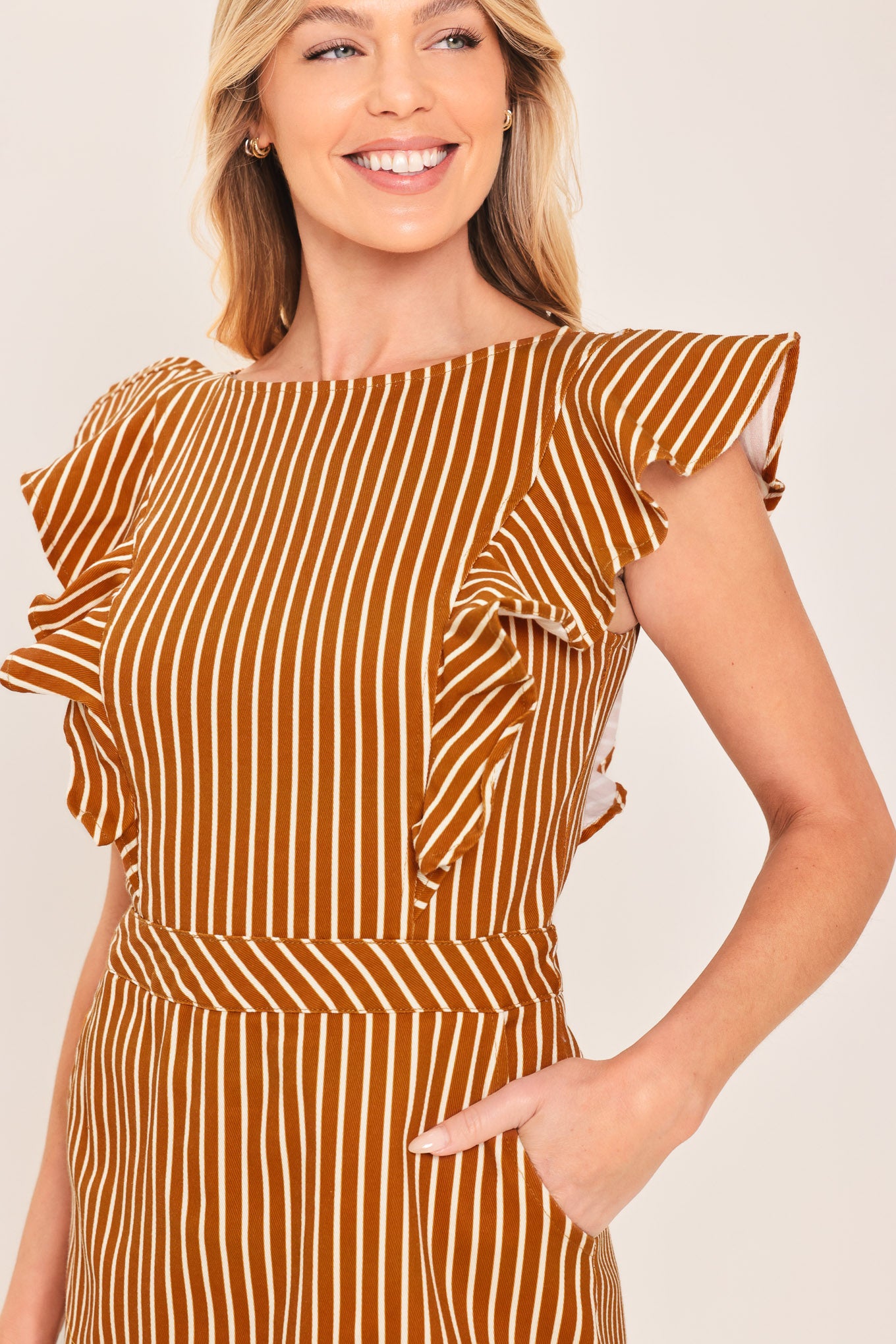 A woman wearing a mini skort romper with vertical rust and white stripes | Flying Tomato
