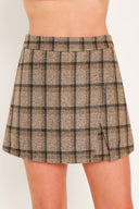 A woman wearing a taupe and brown plaid skort | Flying Tomato