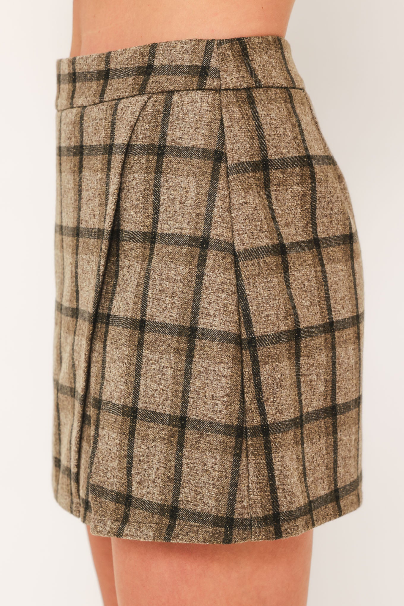 A woman wearing a taupe and brown plaid skort | Flying Tomato