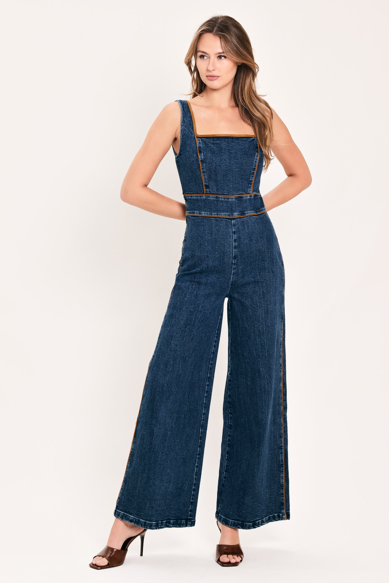 A woman modeling a dark blue denim wide-leg jumpsuit with square neckline | Flying Tomato