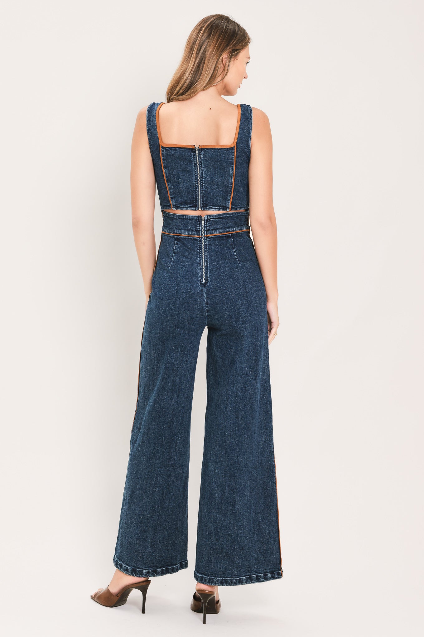 A woman modeling a dark blue denim wide-leg jumpsuit with square neckline | Flying Tomato