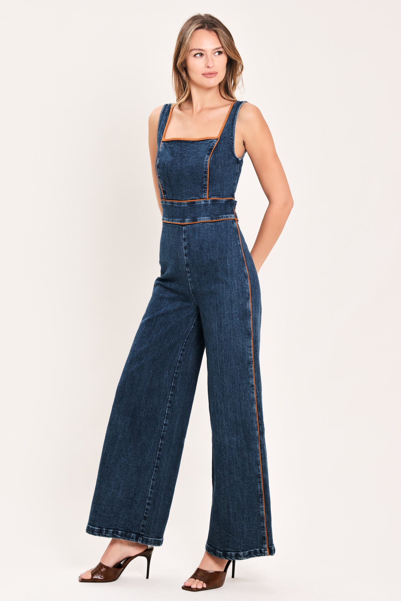 A woman modeling a dark blue denim wide-leg jumpsuit with square neckline | Flying Tomato