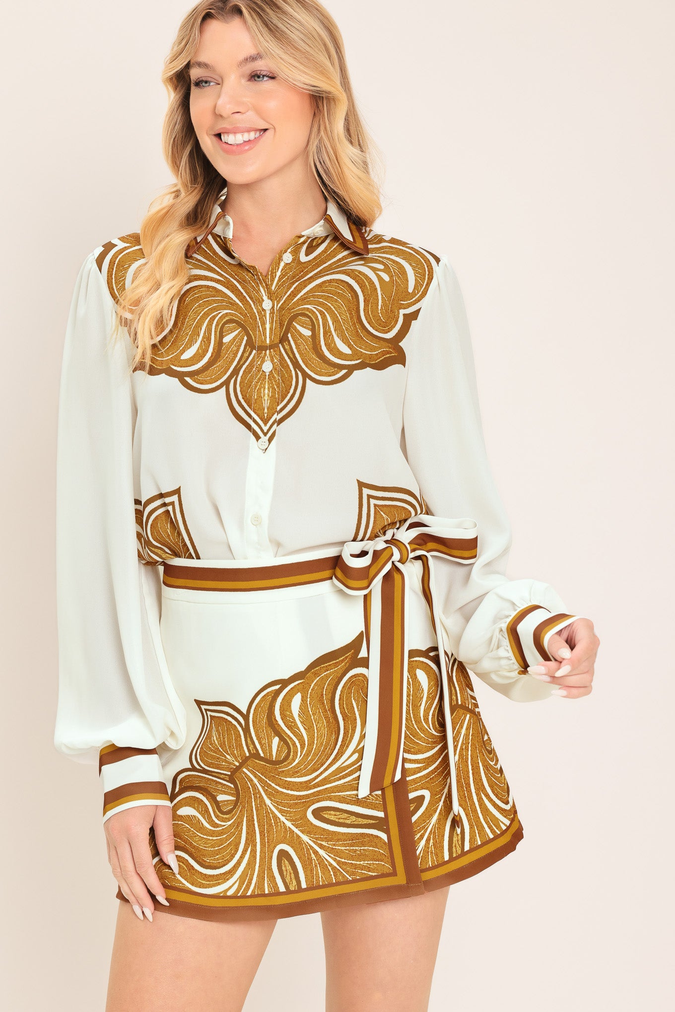 Woman wearing an ivory with brown leaf like print skort with a waist tie | Flying Tomato