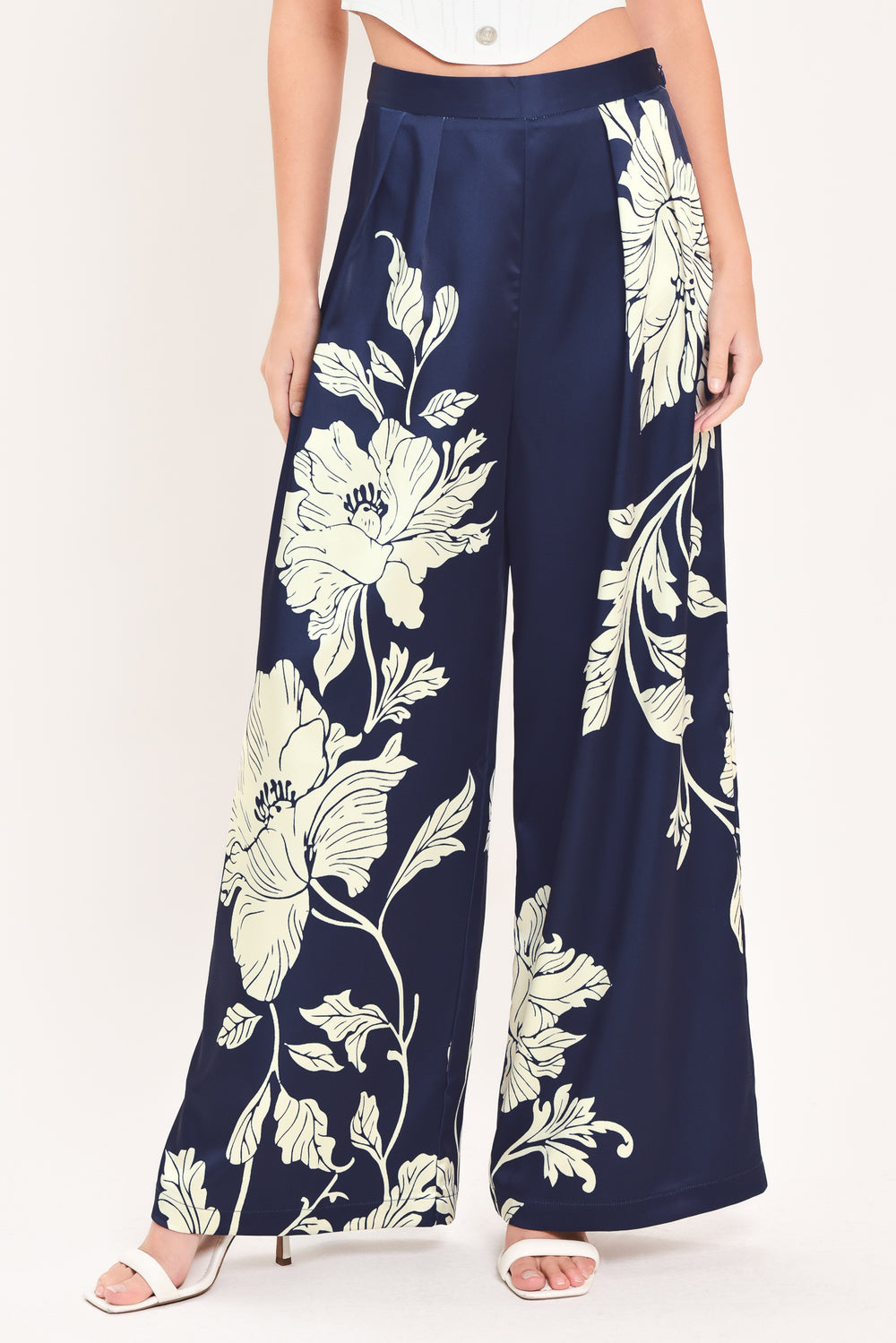 A woman wearing navy blue wide-leg pants with a large cream floral print | Flying Tomato