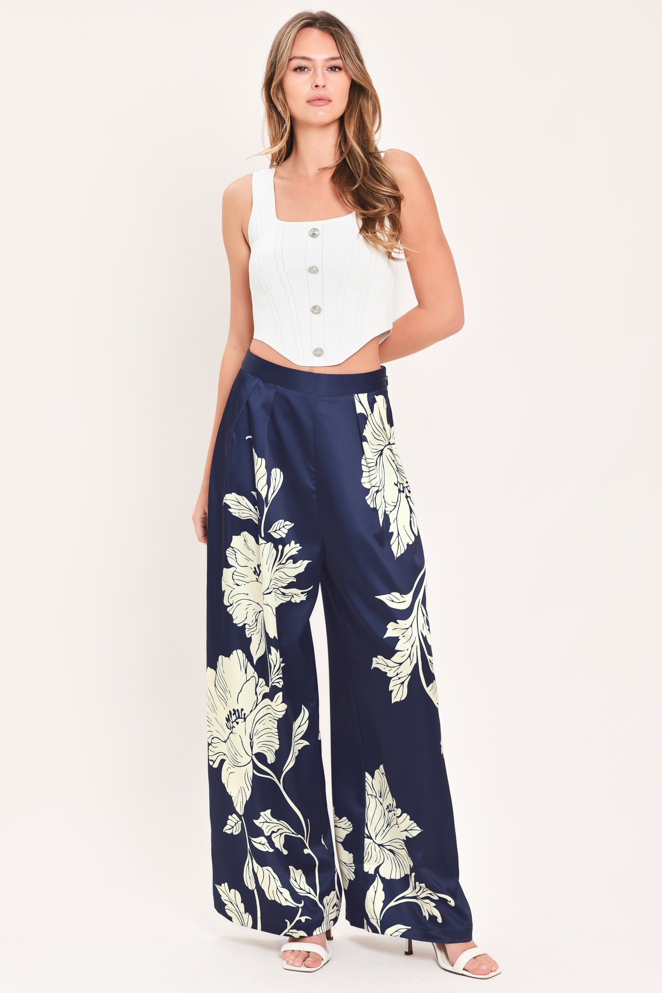 A woman wearing navy blue wide-leg pants with a large cream floral print | Flying Tomato