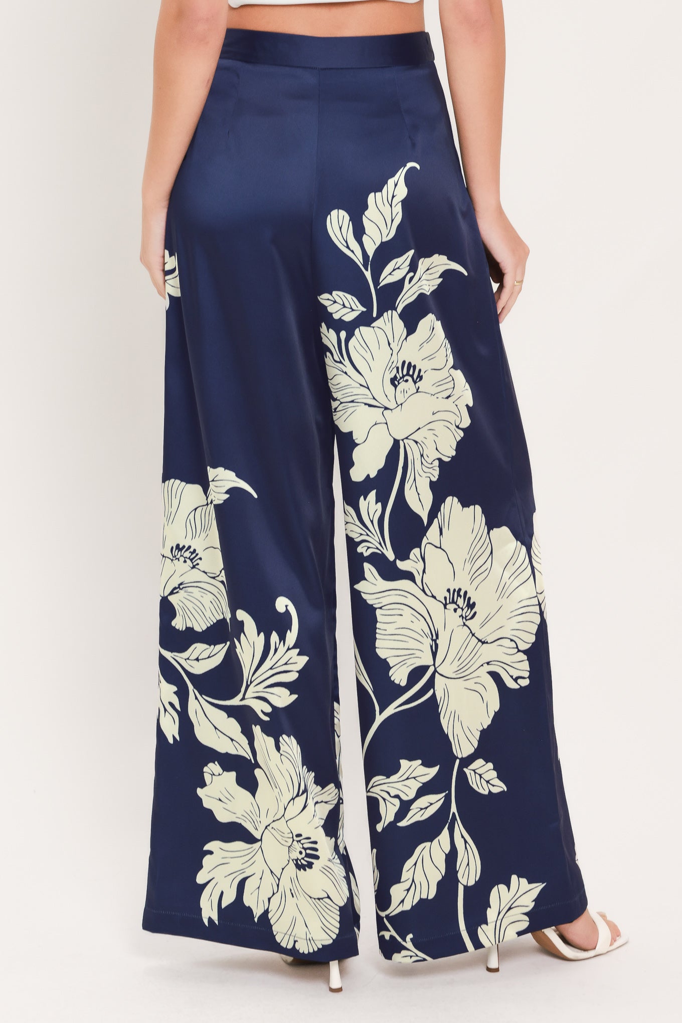 A woman wearing navy blue wide-leg pants with a large cream floral print | Flying Tomato