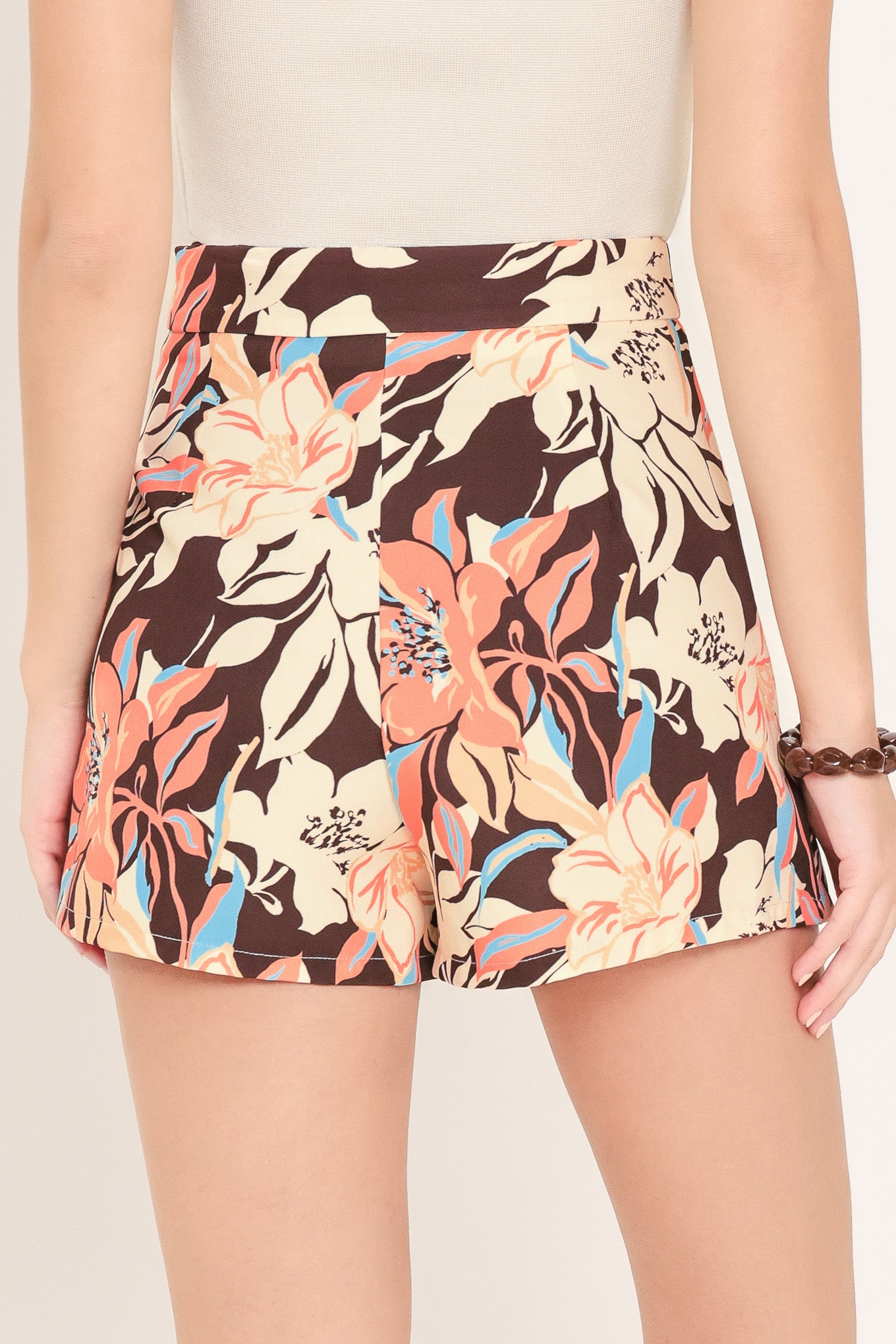 Woman wearing a floral patterned dark brown skort | Flying Tomato