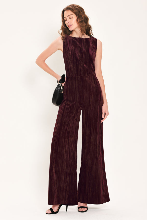 Woman wearing a sleeveless burgundy velvet jumpsuit with wide-leg pants | Flying Tomato