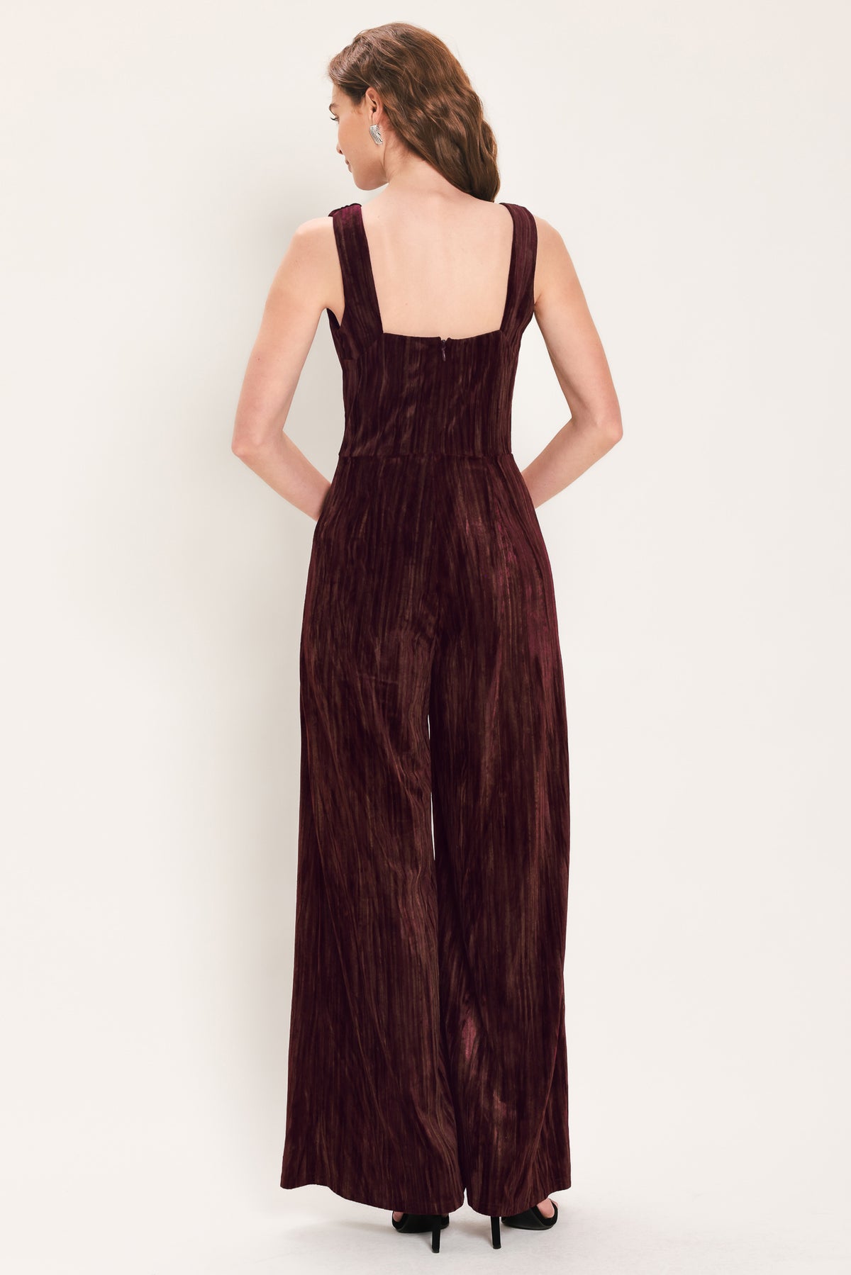 Woman wearing a sleeveless burgundy velvet jumpsuit with wide-leg pants | Flying Tomato