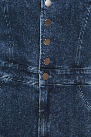 A woman wearing a dark blue denim halter jumpsuit with a button-front bodice and wide flared legs | Flying Tomato 
