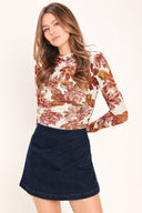 Woman wearing a dark denim skort with side pleat and back zipper closure | Flying Tomato