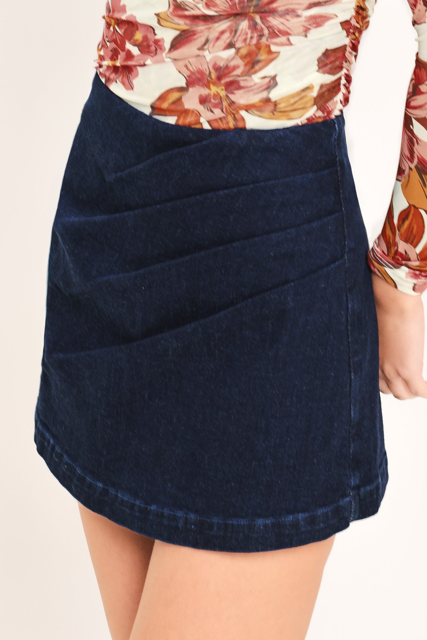 Woman wearing a dark denim skort with side pleat and back zipper closure | Flying Tomato