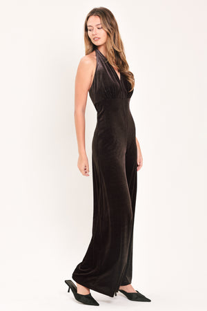 Woman wearing a brown velvet halter, backless jumpsuit | Flying Tomato
