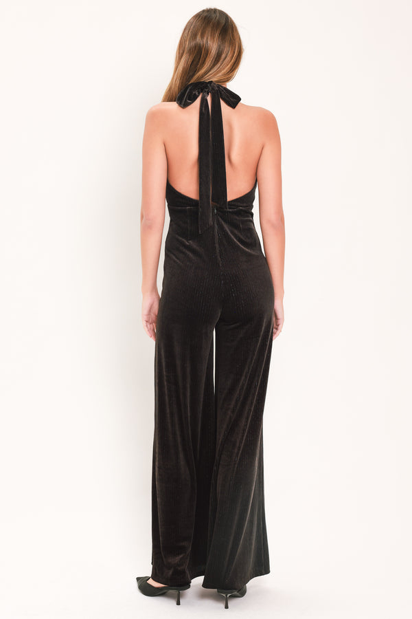 Woman wearing a brown velvet halter, backless jumpsuit | Flying Tomato