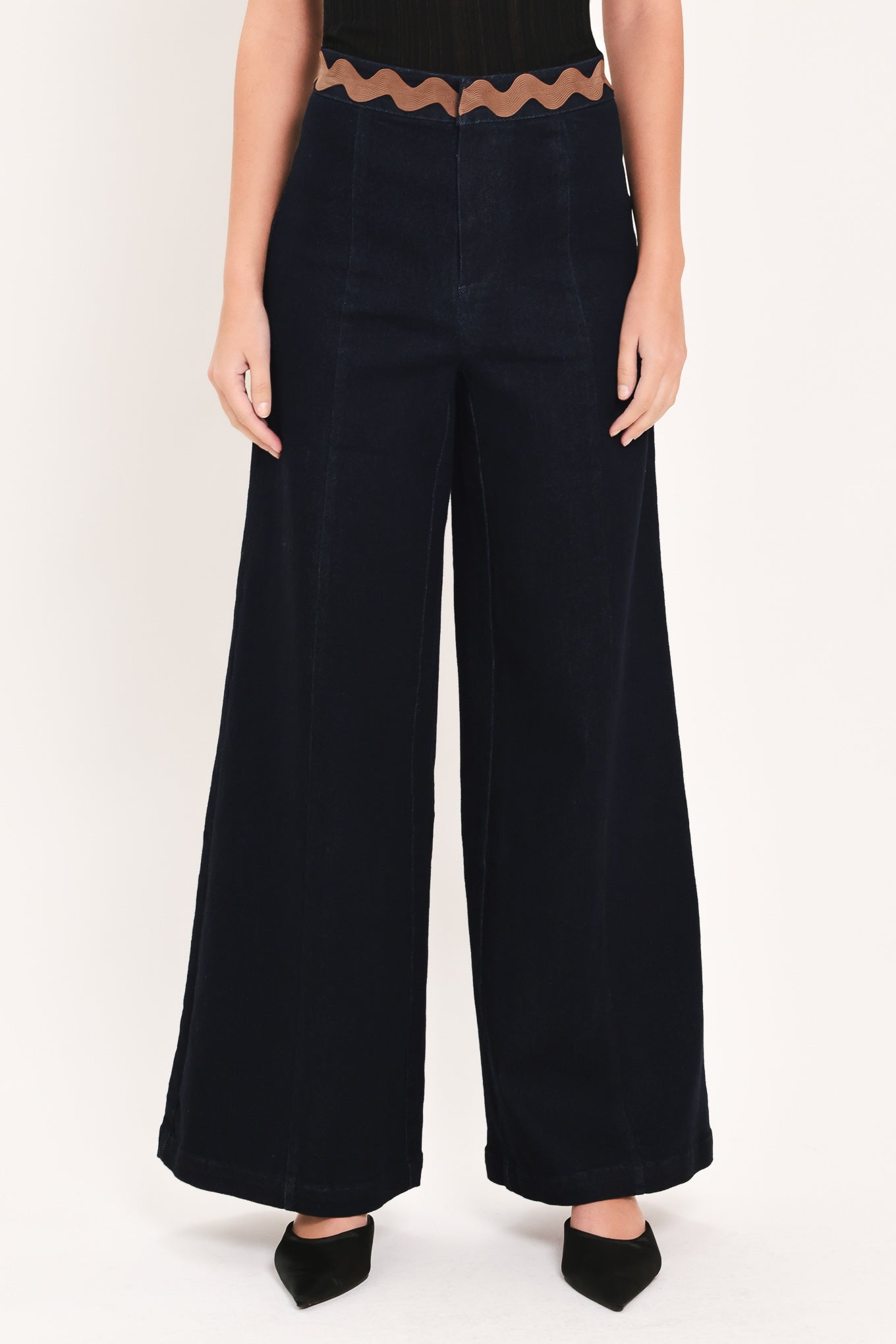 A model is wearing a pair of wide-leg navy blue pants with a distinctive scalloped brown waistband | Flying Tomato