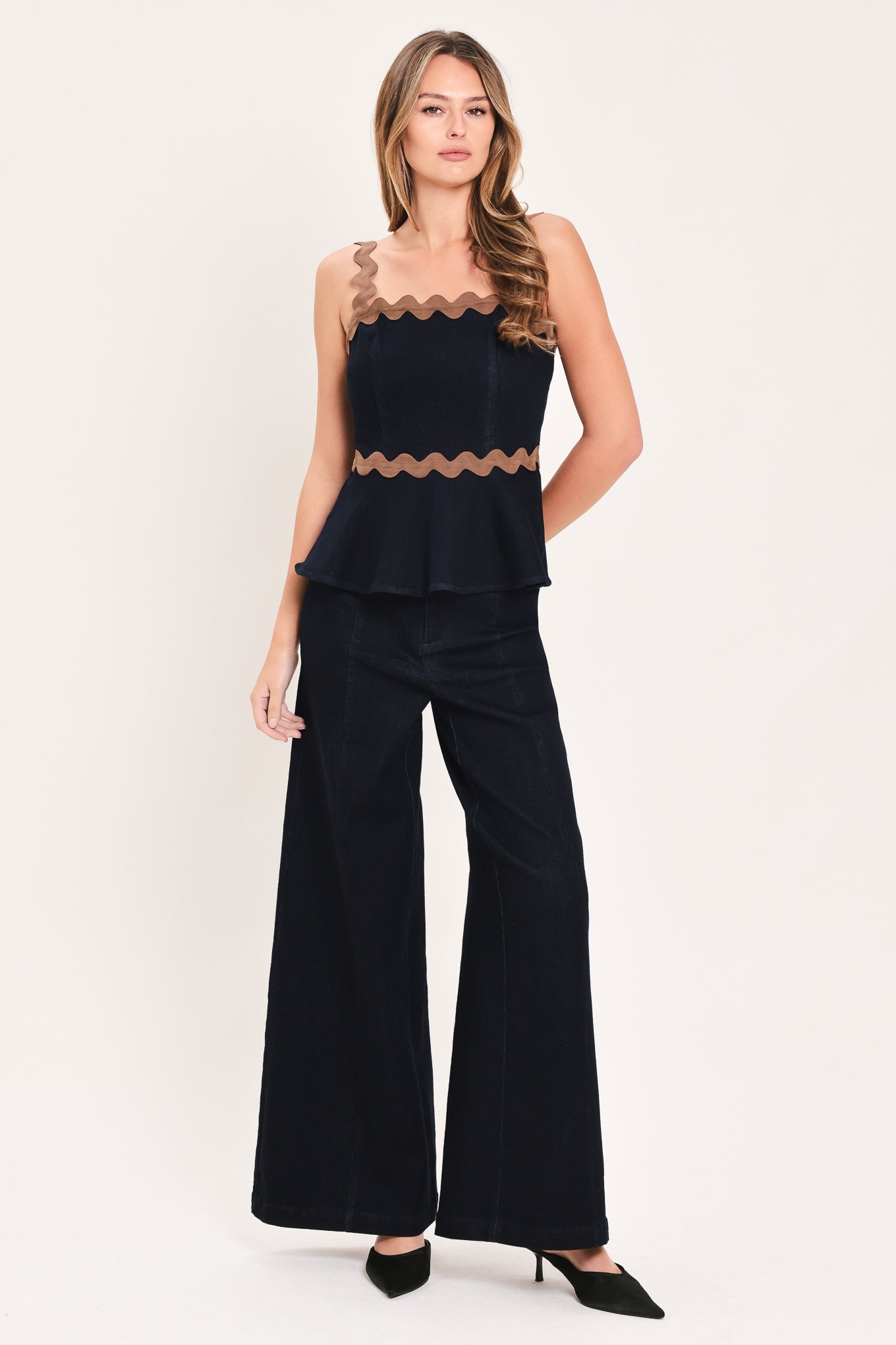 A model is wearing a pair of wide-leg navy blue pants with a distinctive scalloped brown waistband | Flying Tomato