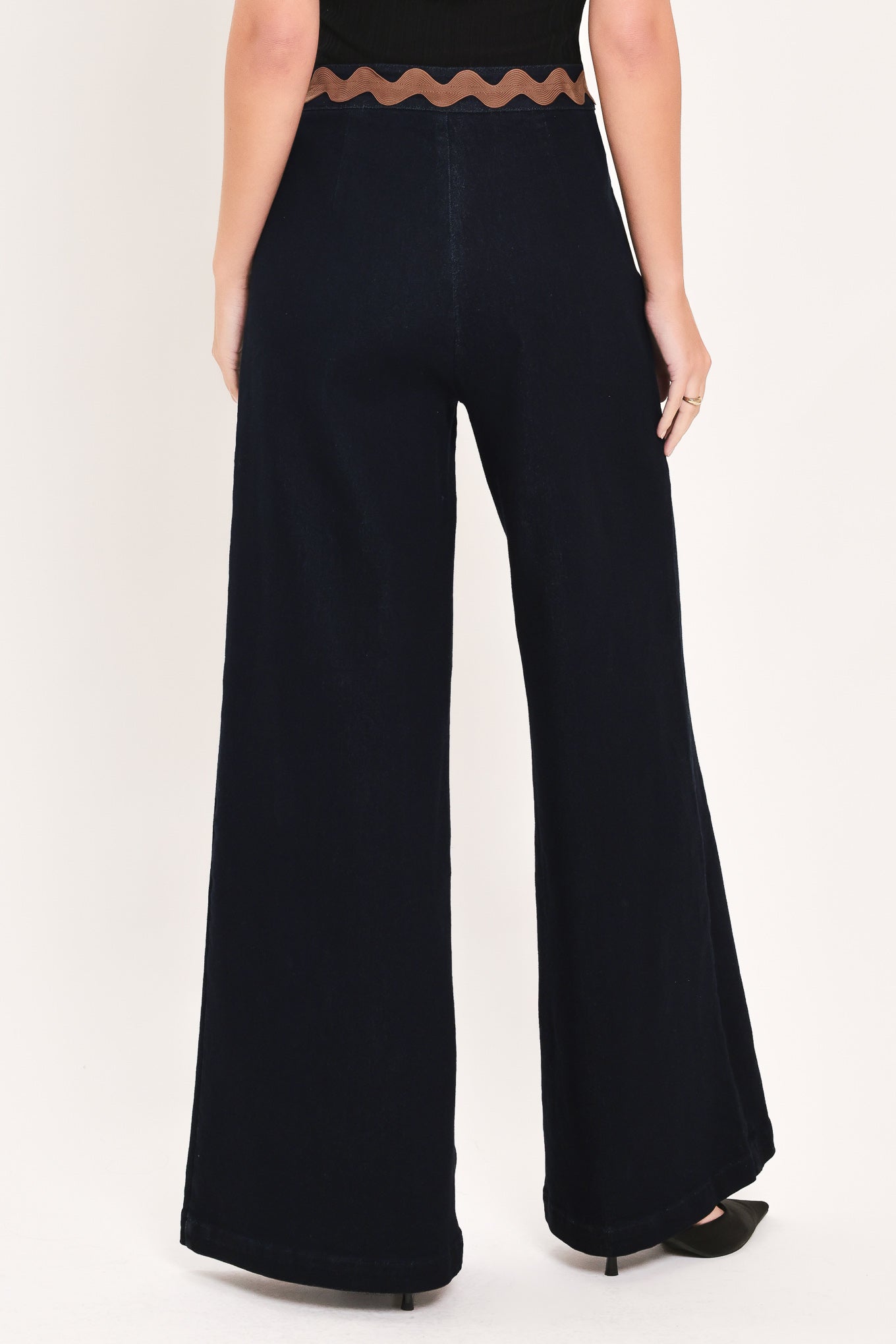 A model is wearing a pair of wide-leg navy blue pants with a distinctive scalloped brown waistband | Flying Tomato
