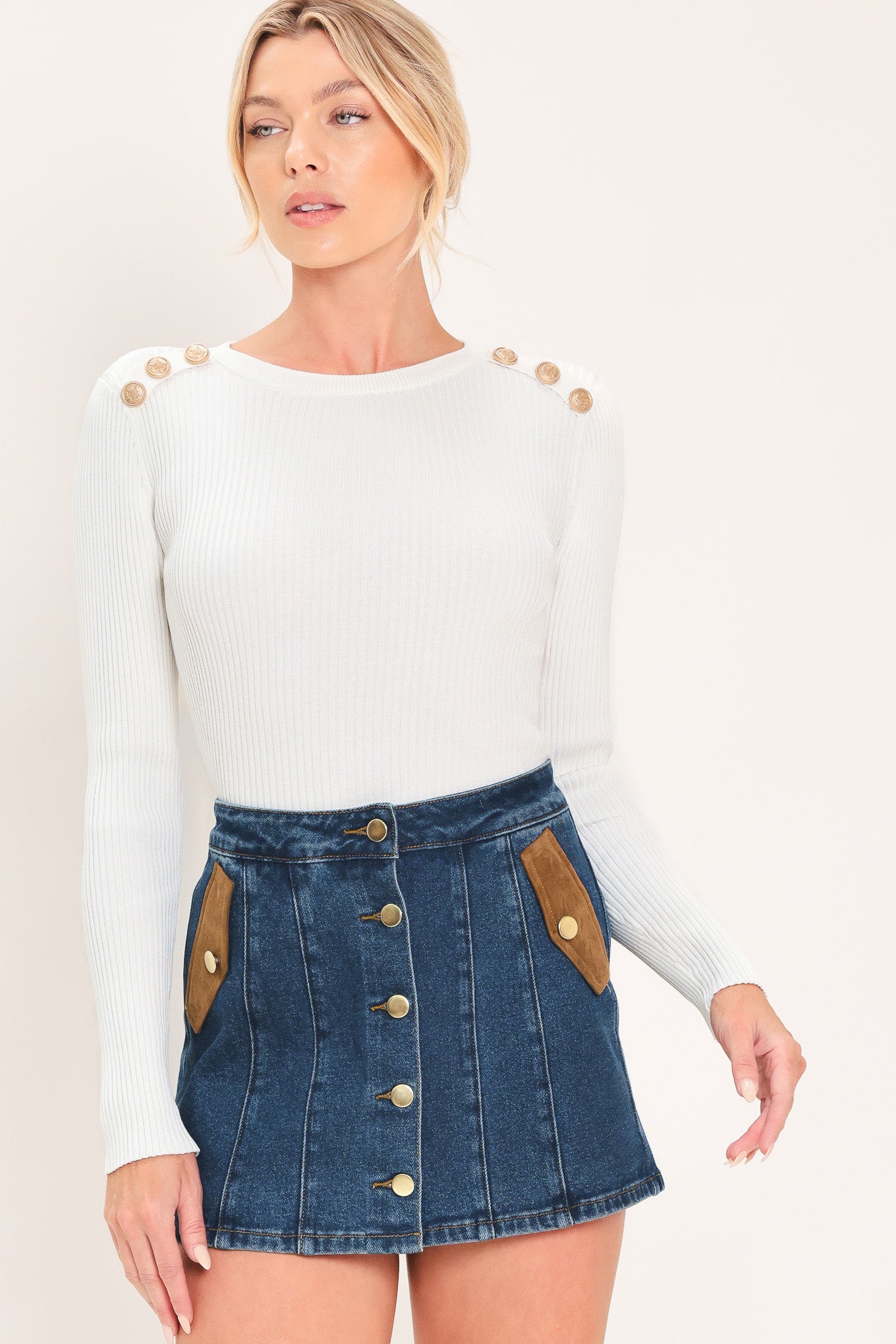 A blue denim mini skort with a button-front closure and brown suede-like side pockets, shown on a model | Flying Tomato