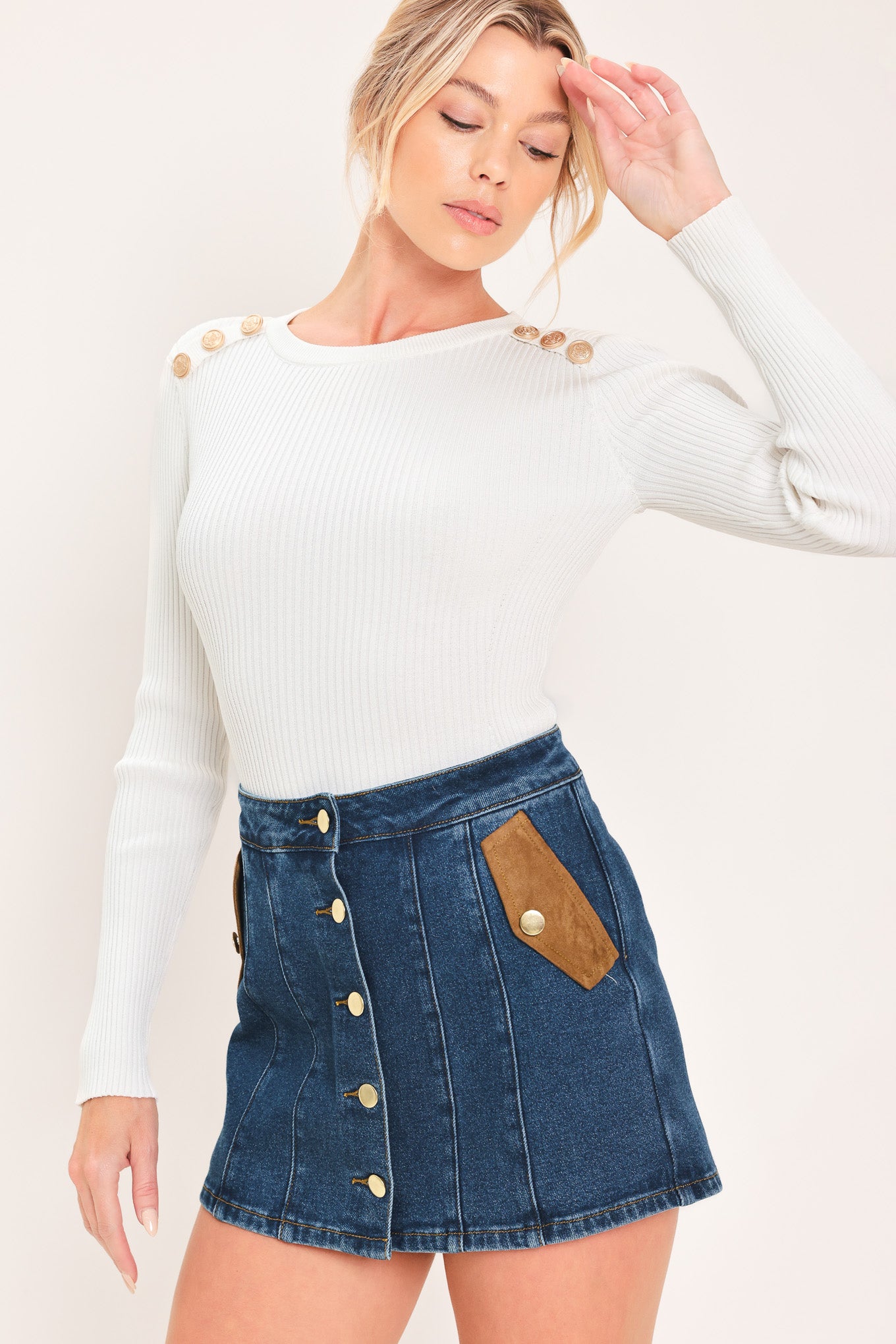 A blue denim mini skort with a button-front closure and brown suede-like side pockets, shown on a model | Flying Tomato