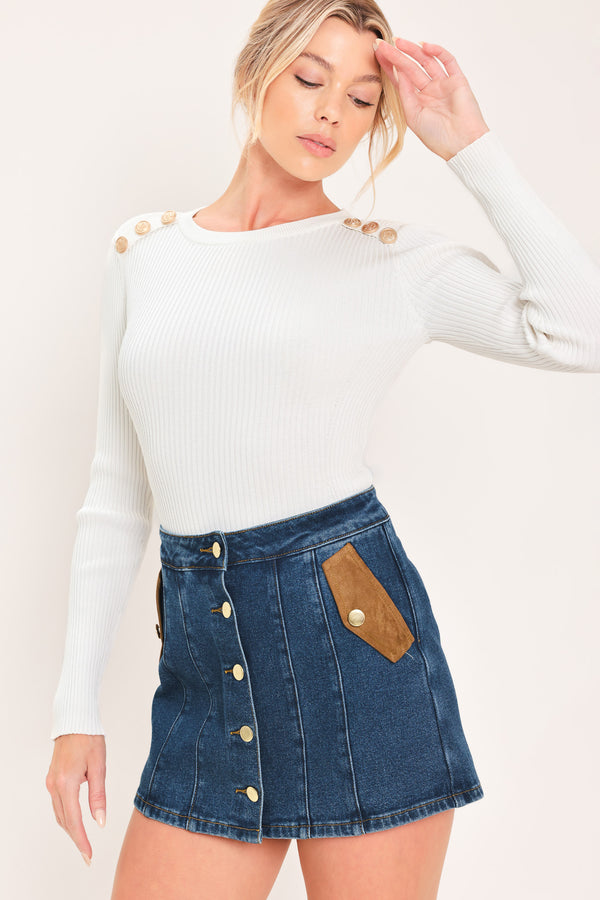 A blue denim mini skort with a button-front closure and brown suede-like side pockets, shown on a model | Flying Tomato