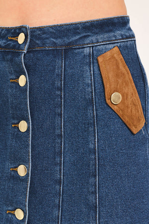 A blue denim mini skort with a button-front closure and brown suede-like side pockets, shown on a model | Flying Tomato