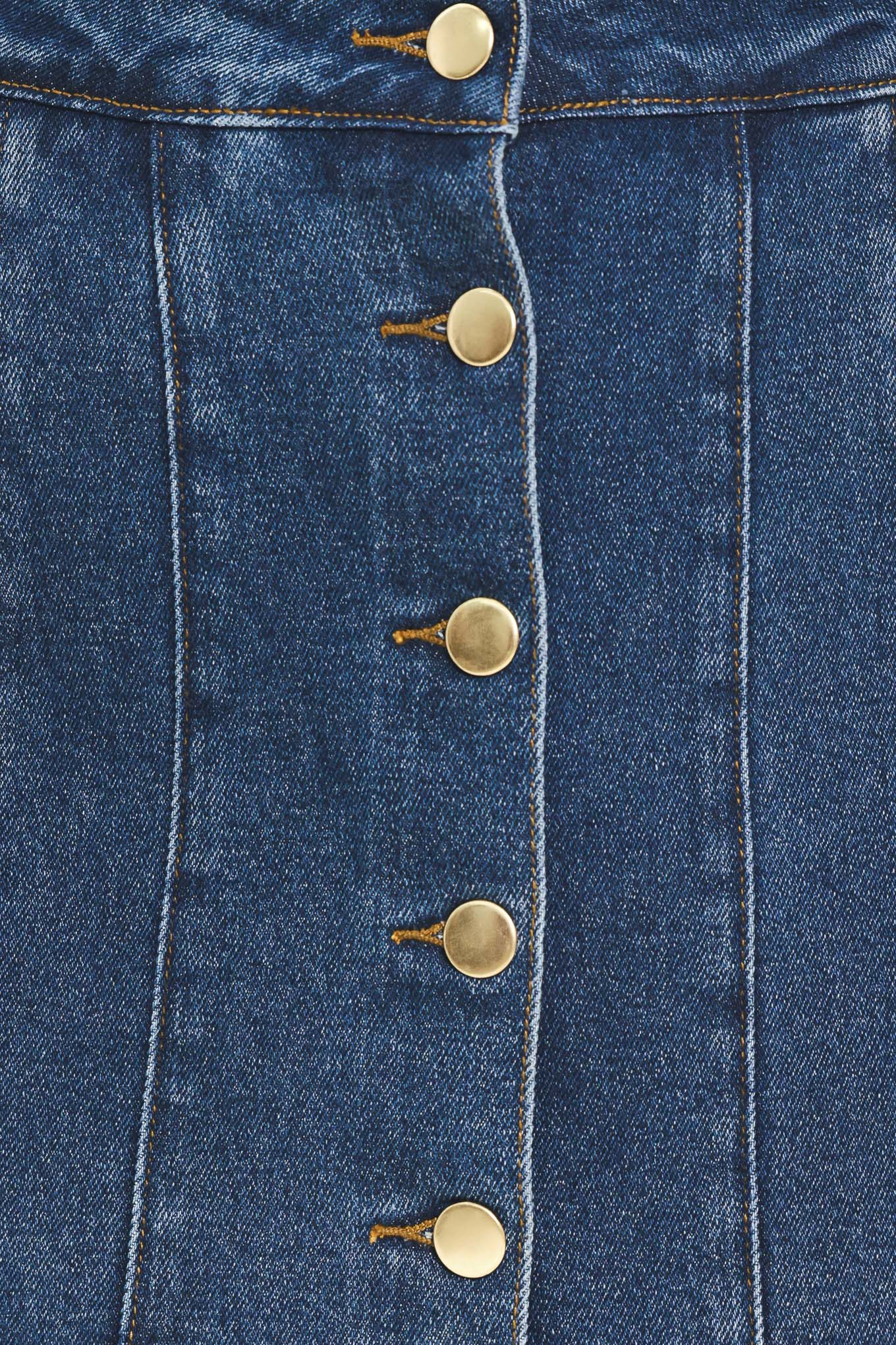 A blue denim mini skort with a button-front closure and brown suede-like side pockets, shown on a model | Flying Tomato