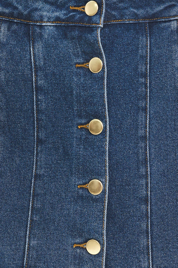 A blue denim mini skort with a button-front closure and brown suede-like side pockets, shown on a model | Flying Tomato