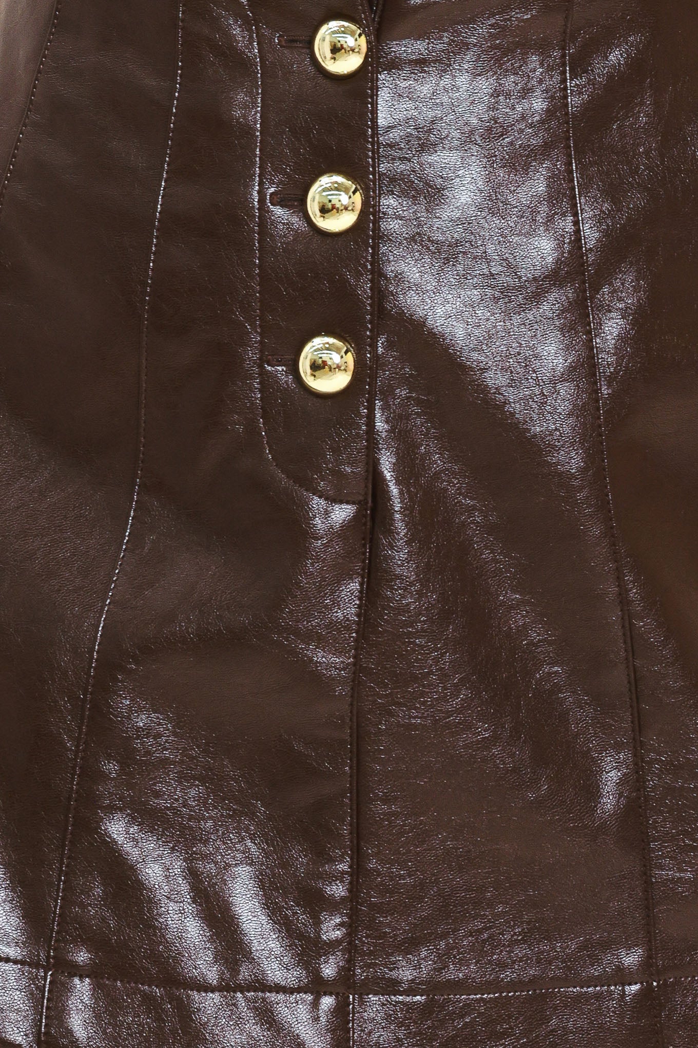 Woman wearing a dark brown faux leather skort with gold buttons on the front | Flying Tomato