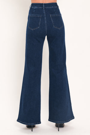 A model wearing dark blue high-waisted flare jeans with distinctive gold-colored contrast stitching running down the center of the legs | Flying Tomato