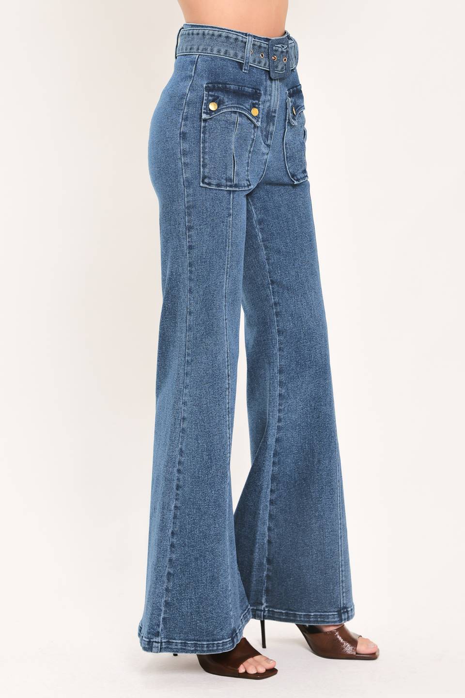 A woman wearing blue high-waisted flare jeans with front flap pockets and gold-tone button details | Flying Tomato
