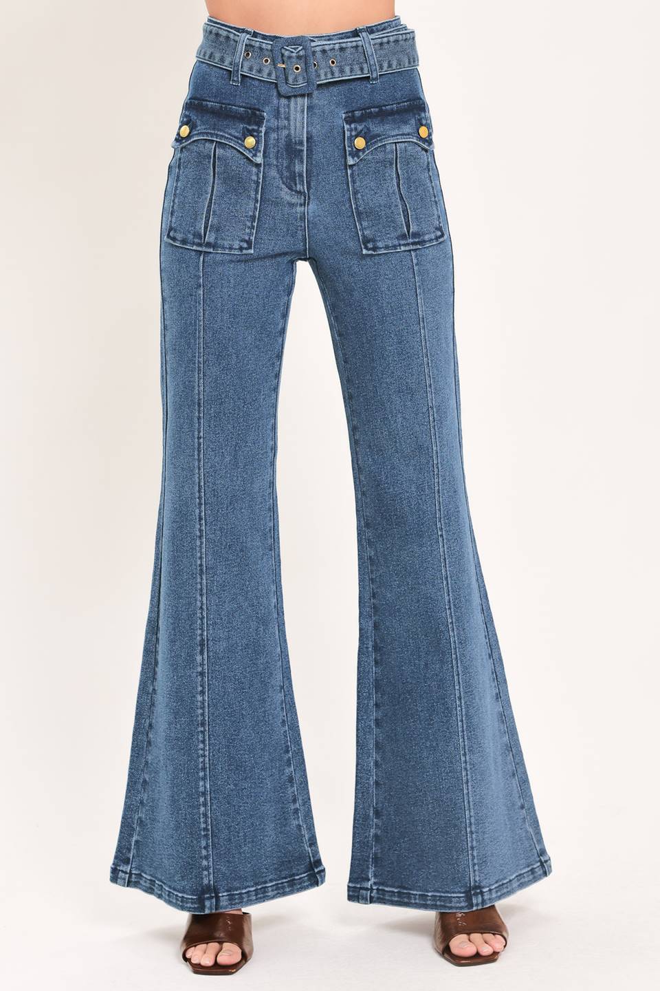 A woman wearing blue high-waisted flare jeans with front flap pockets and gold-tone button details | Flying Tomato