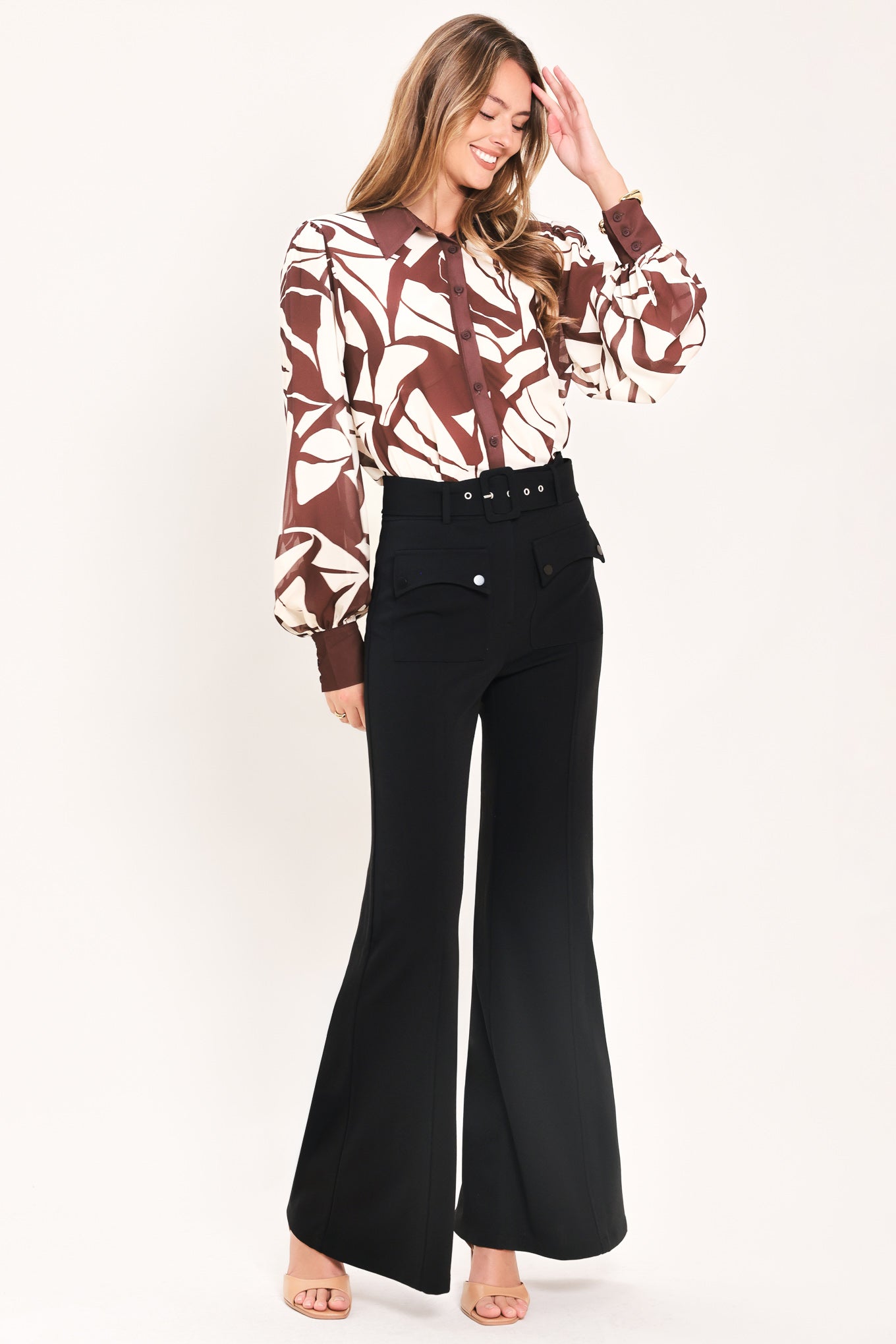 Woman wearing a pair of black pants with a belt and front pockets | Flying Tomato