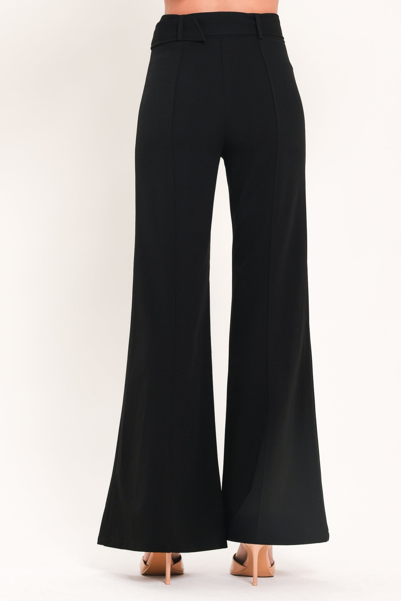 Woman wearing a pair of black pants with a belt and front pockets | Flying Tomato