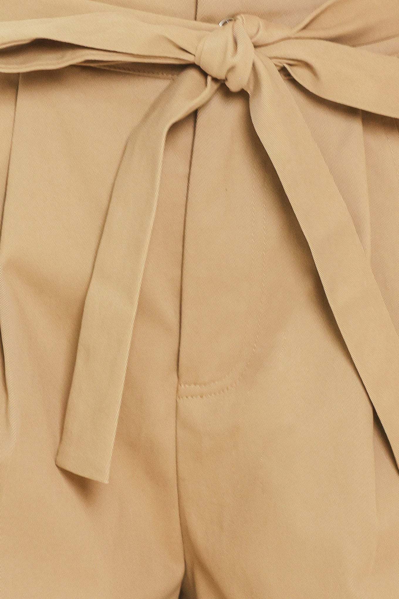 Woman wearing a taupe beige high waisted shorts with a self tie matching belt | Flying Tomato