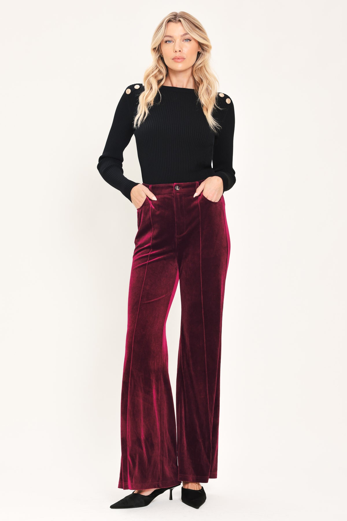 A pair of high-waisted, wide-leg velvet pants in a deep burgundy red, shown on a model | Flying Tomato