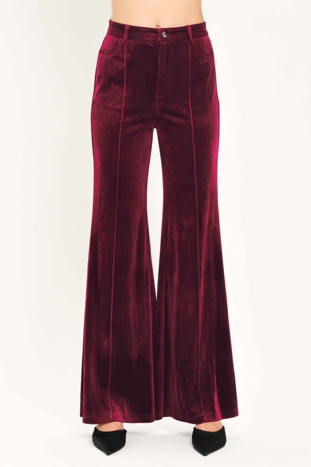 A pair of high-waisted, wide-leg velvet pants in a deep burgundy red, shown on a model | Flying Tomato