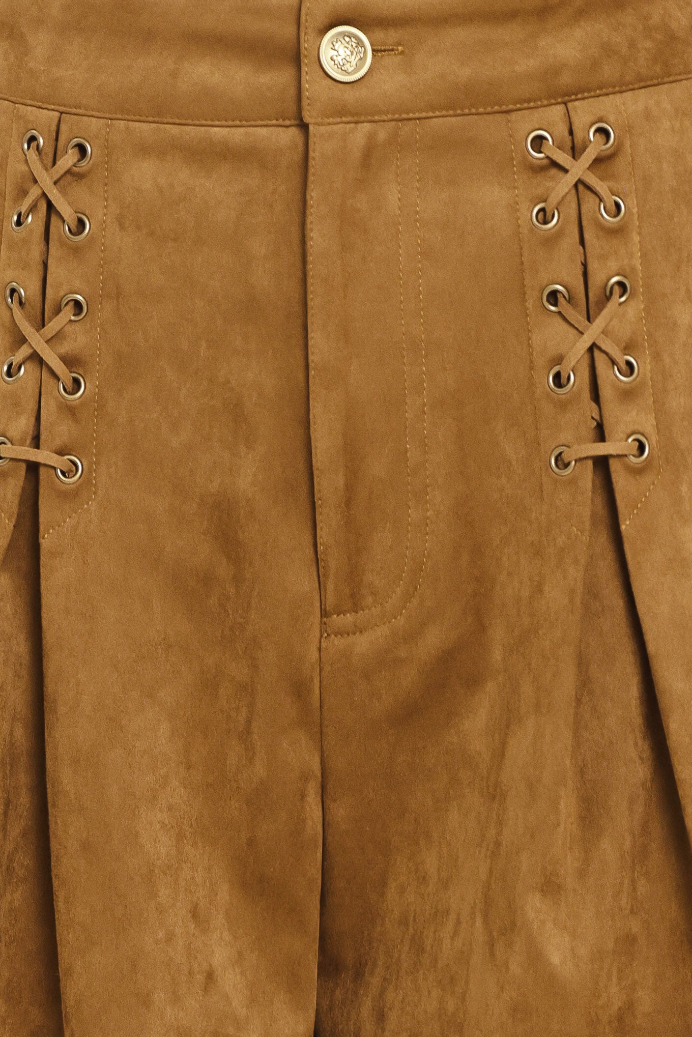 A woman wearing a camel suede mini skort with pleated detailing and lace-up front accents | Flying Tomato