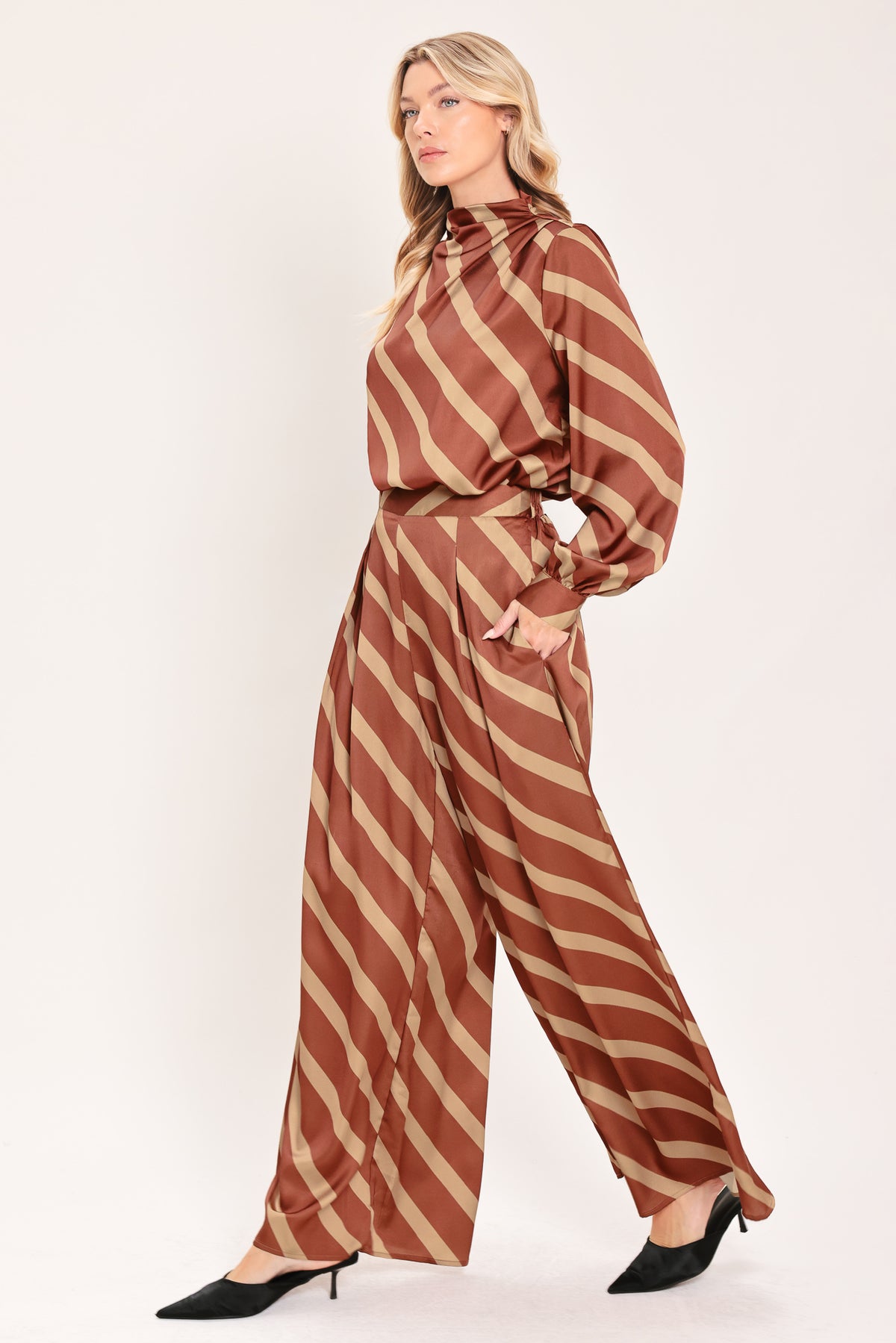 A pair of wide-leg pants with a diagonal striped pattern in rust brown and beige, shown on a model | Flying Tomato