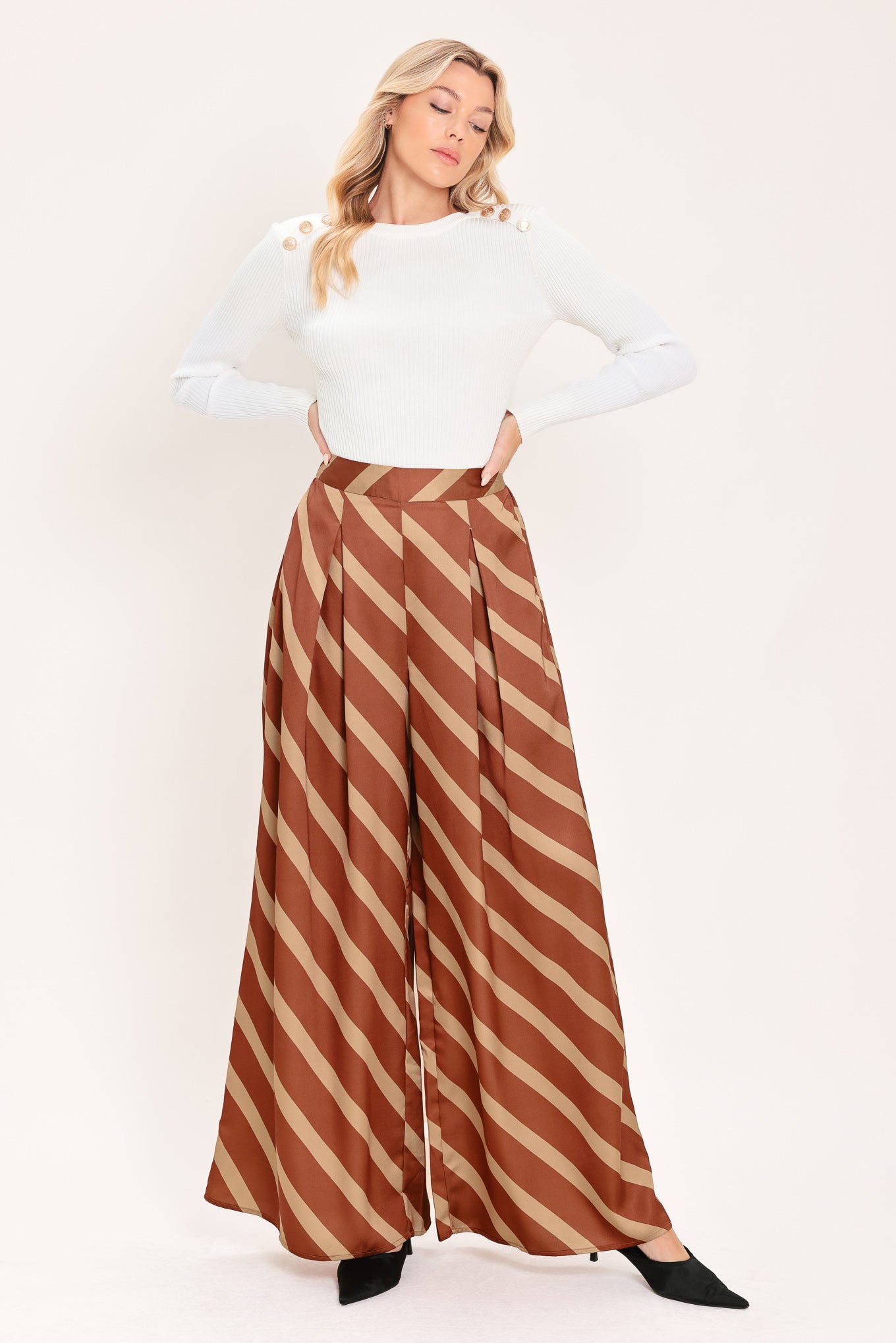 A pair of wide-leg pants with a diagonal striped pattern in rust brown and beige, shown on a model | Flying Tomato
