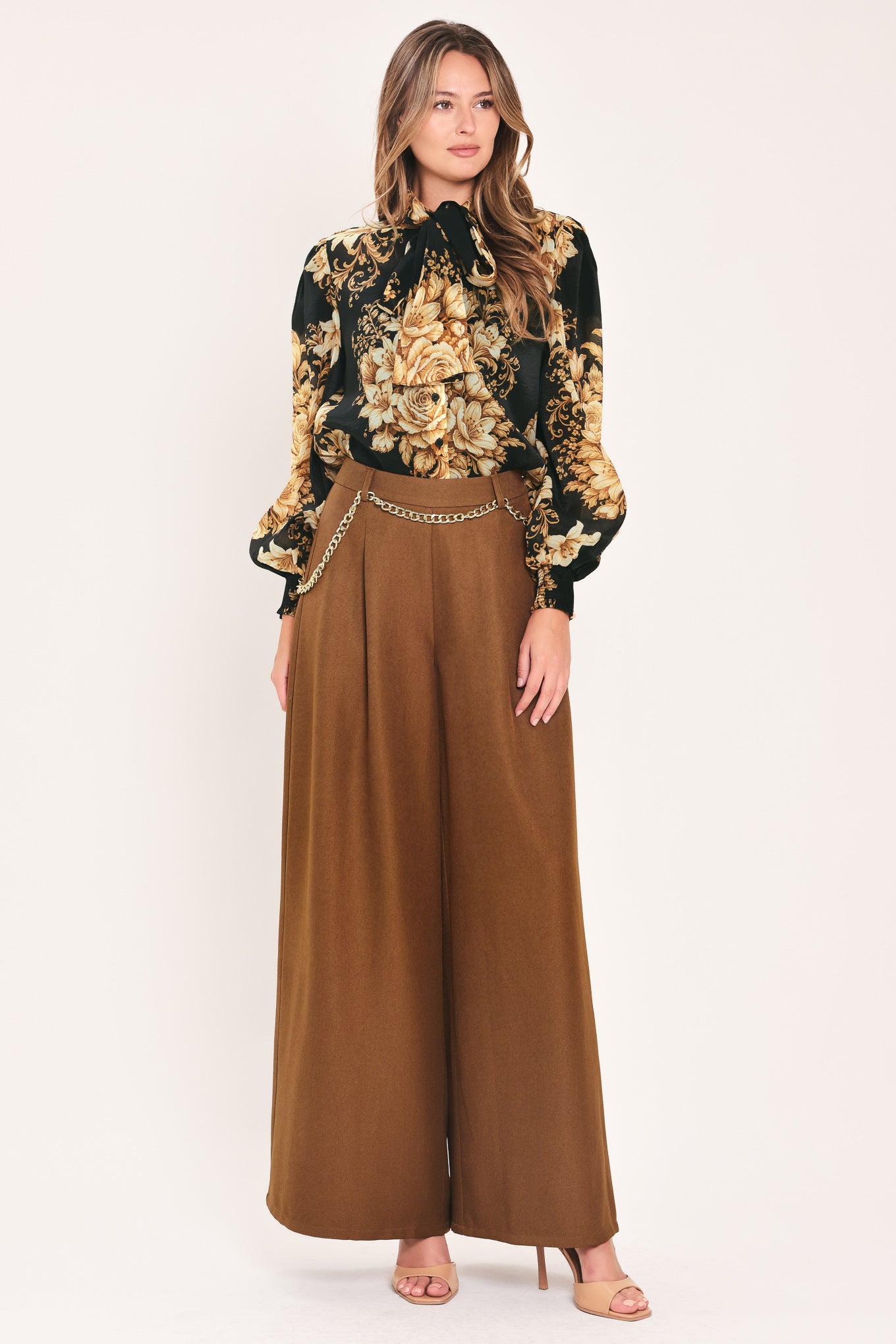 A person wearing high-waisted, wide-leg brown pants with a decorative gold chain belt detail at the waist | Flying Tomato