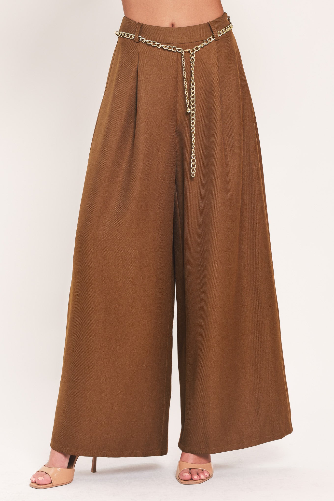 A person wearing high-waisted, wide-leg brown pants with a decorative gold chain belt detail at the waist | Flying Tomato