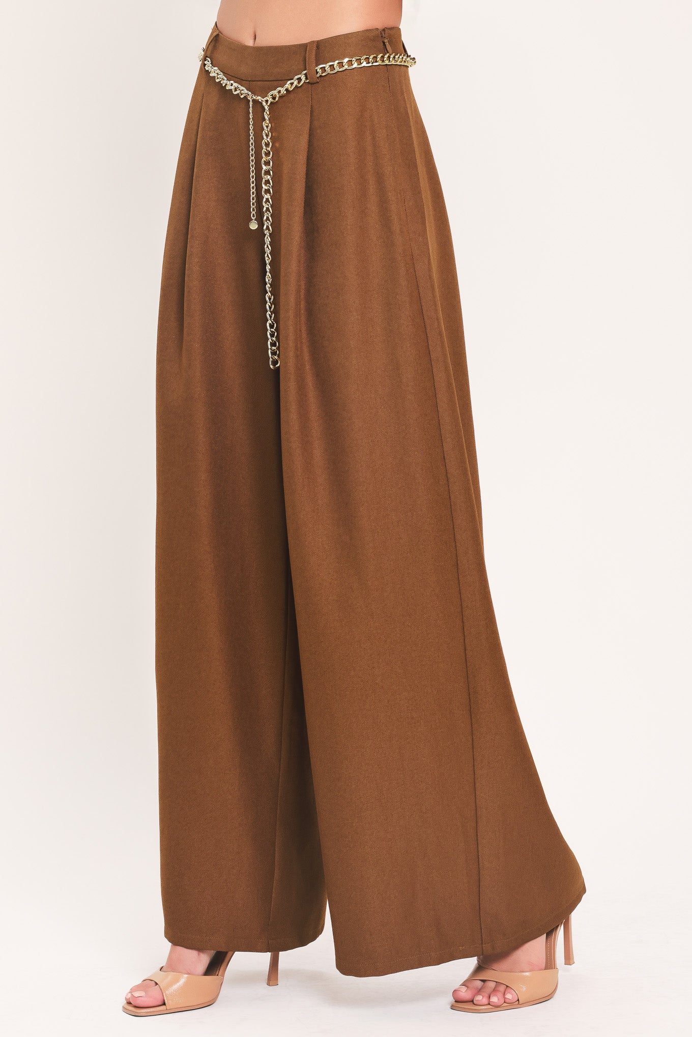 A person wearing high-waisted, wide-leg brown pants with a decorative gold chain belt detail at the waist | Flying Tomato