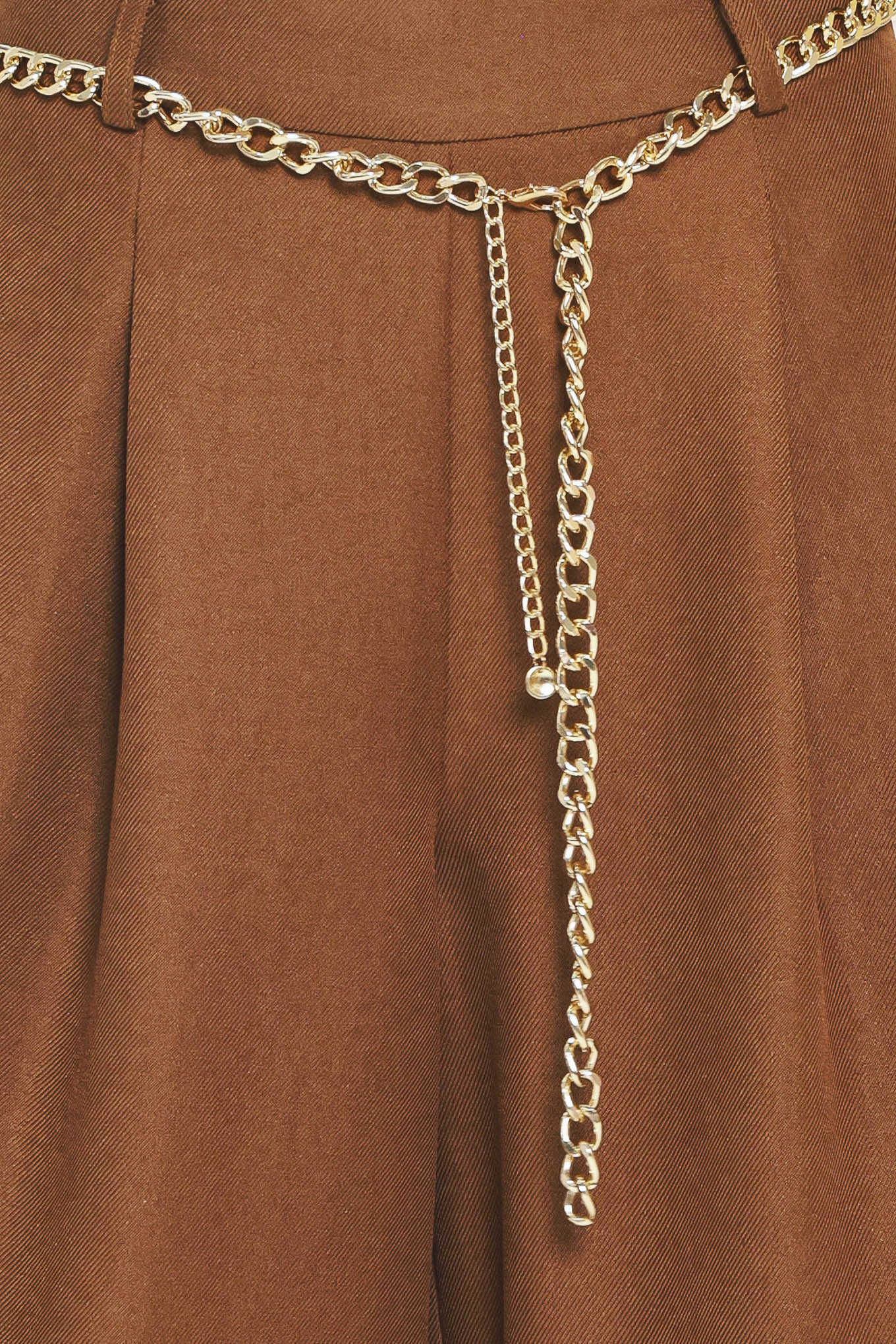 A person wearing high-waisted, wide-leg brown pants with a decorative gold chain belt detail at the waist | Flying Tomato
