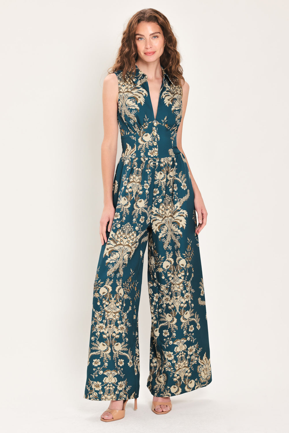 Woman wearing a teal blue jumpsuit with a collar v neckline, and beige baroque print | Flying Tomato