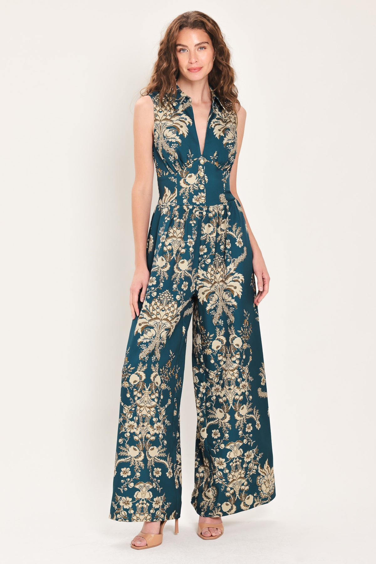 Woman wearing a teal blue jumpsuit with a collar v neckline, and beige baroque print | Flying Tomato
