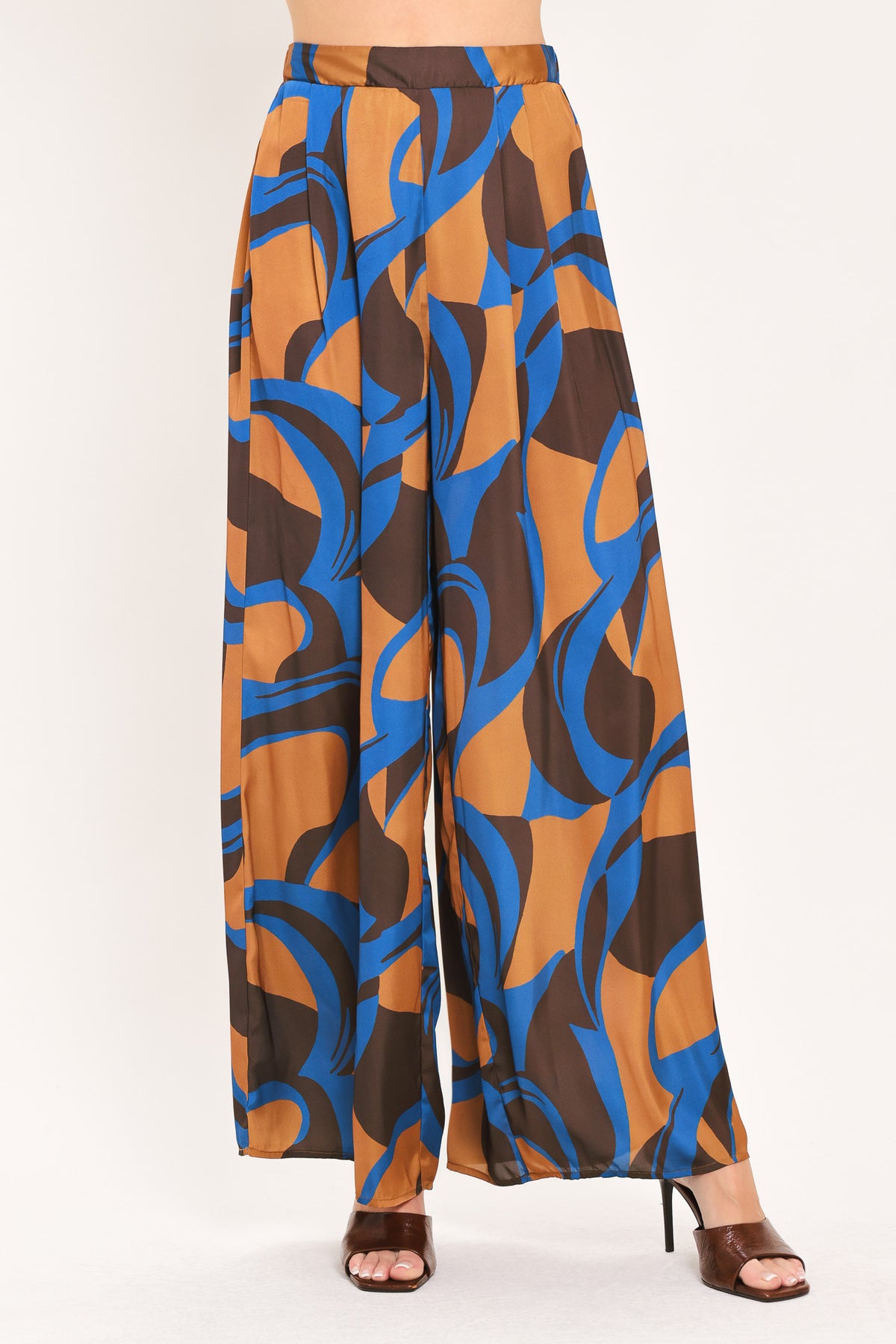 A woman modeling wide-leg pants with a bold abstract swirl pattern in brown, blue, and black | Flying Tomato