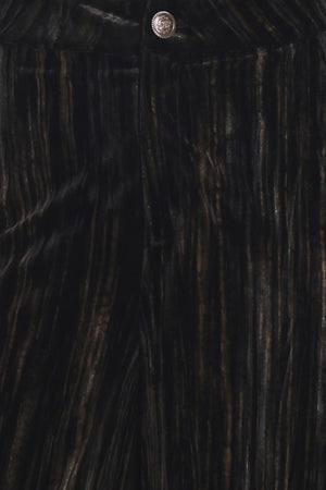 A model wearing high-waisted, wide-leg black pleated velvet trousers with a button waistband | Flying Tomato