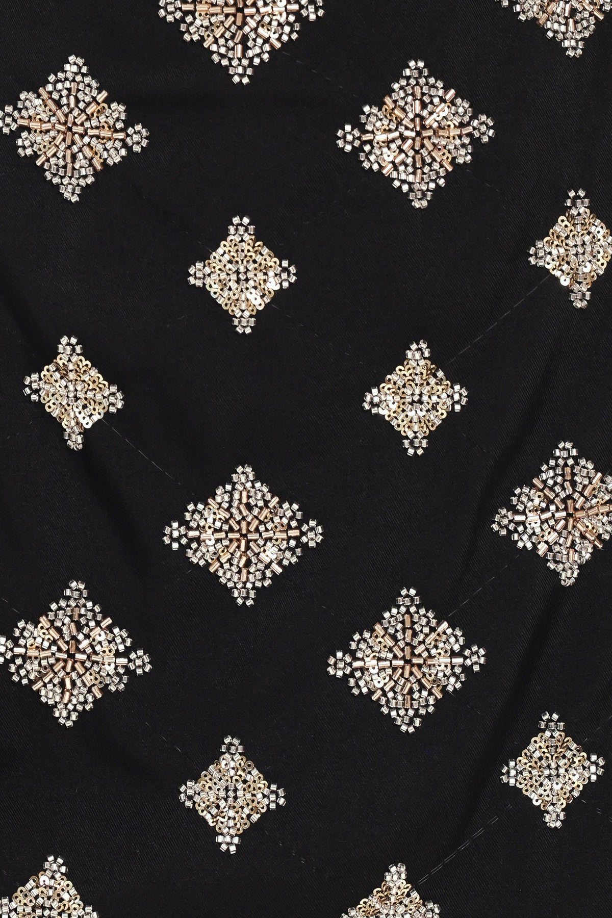 A black A-line mini skort with an allover pattern of metallic gold and silver rhinestone medallions, shown on a model | Flying Tomato