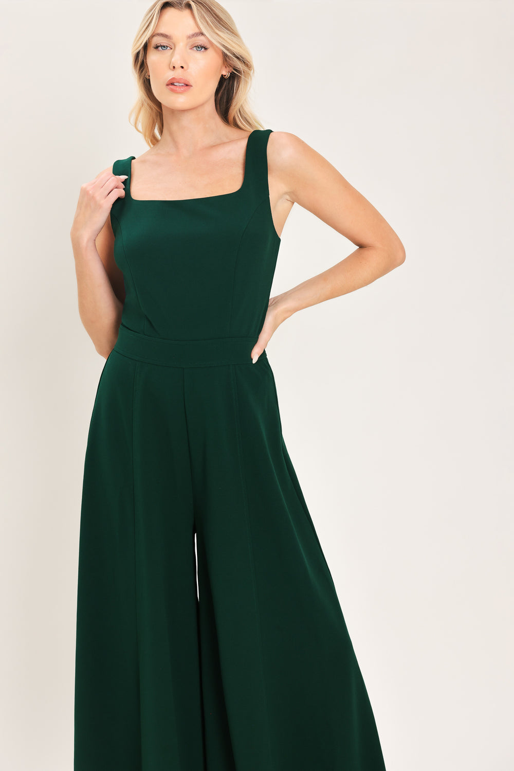 Woman wearing a sleeveless square neck solid hunter green wide-leg jumpsuit | Flying Tomato